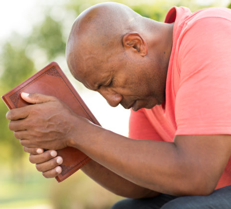 Man praying and reading the Bible.